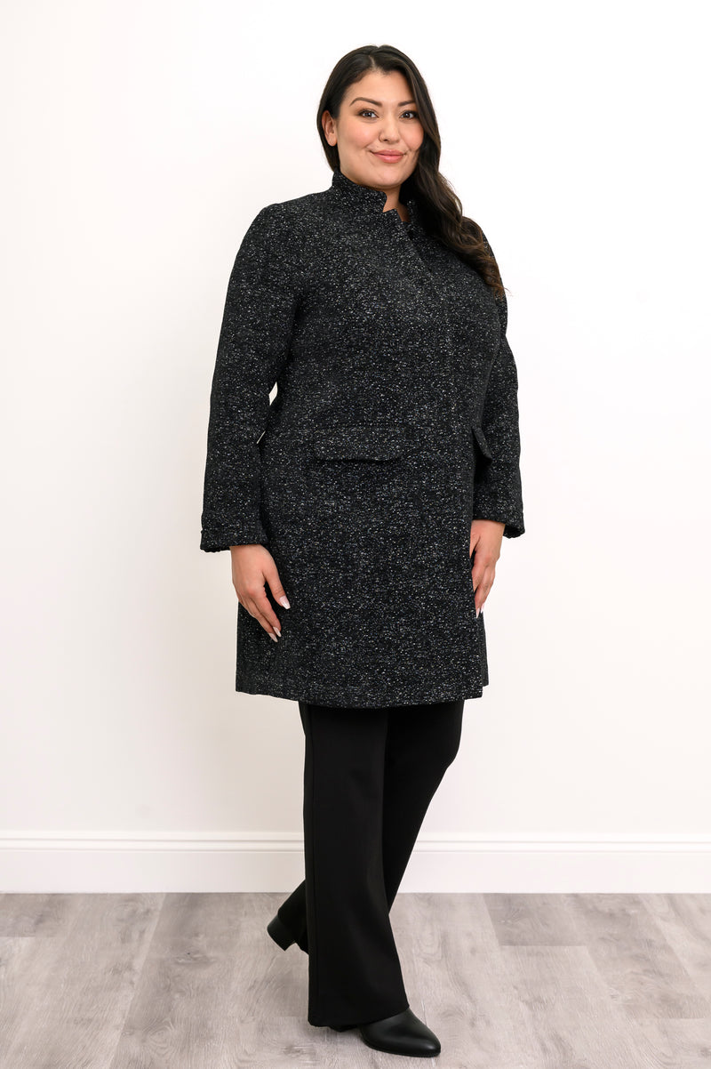Side view of woman wearing long black coat with mandarin collar and flap pockets