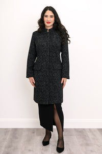 Full front view of woman in textured wool coat and black skirt with slit detail