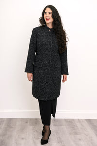 Woman smiling in long black boiled wool coat with mandarin collar styled with black pencil skirt