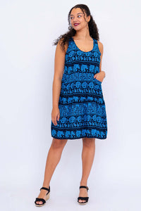 Woman wearing blue elephant print dress, front angled pose with hand in pocket