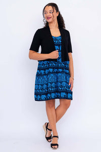Woman in blue elephant print dress paired with a black short-sleeved cardigan, front angle