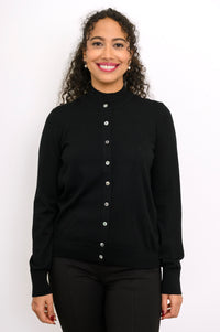 Close up front view of a smiling woman wearing a black fine knit merino wool crewneck cardigan.