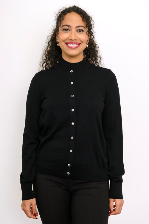 Close up front view of a smiling woman wearing a black fine knit merino wool crewneck cardigan.