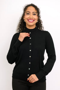 Woman modeling a monochromatic black outfit featuring a long sleeve crewneck cardigan and trousers.