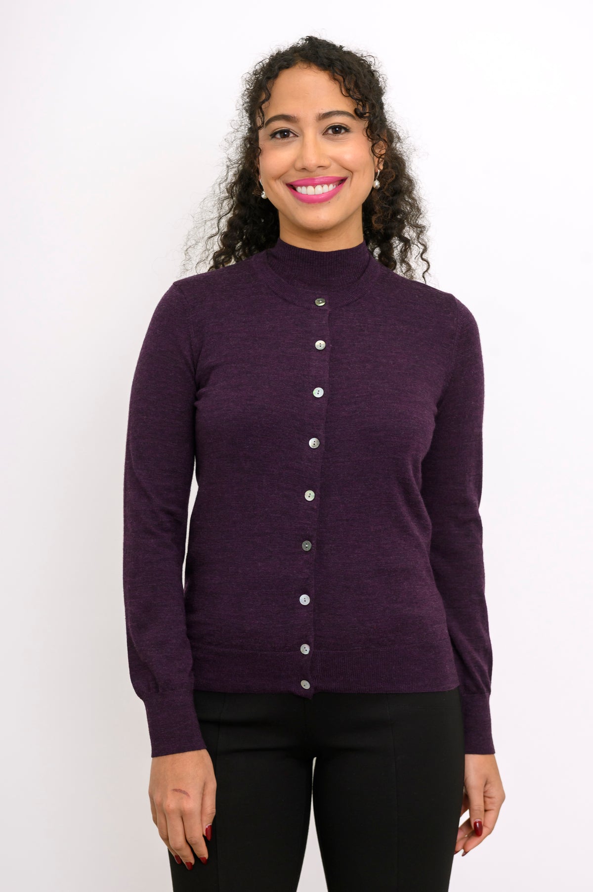 Front view of woman wearing a purple cardigan on a purple top and black pants against a white background