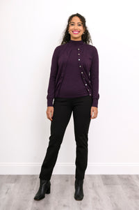 Front view of woman wearing a purple cardigan on a purple top and black pants against a white background