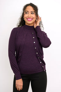 Front view of woman wearing a purple cardigan on a purple top and black pants against a white background