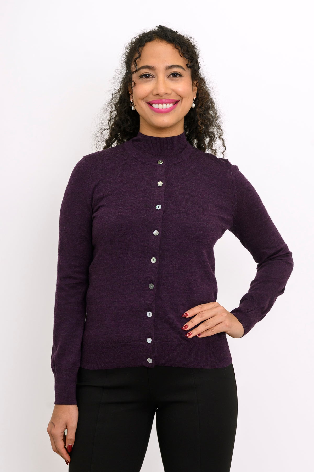 Front view of woman wearing a purple cardigan and black pants against a white background