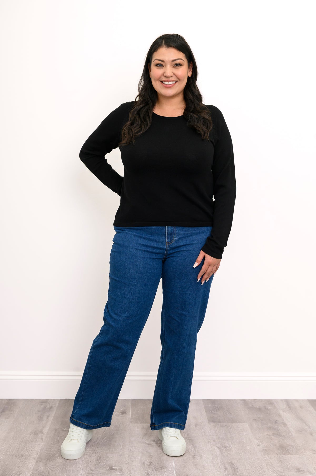 Black long-sleeve sweater featuring clean flat-finished wrist cuffs, shown in a relaxed standing front pose.