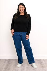 Front view of a loose-fit women's dark raglan sleeve sweater, showcasing a straight-cut hemline and casual frame.
