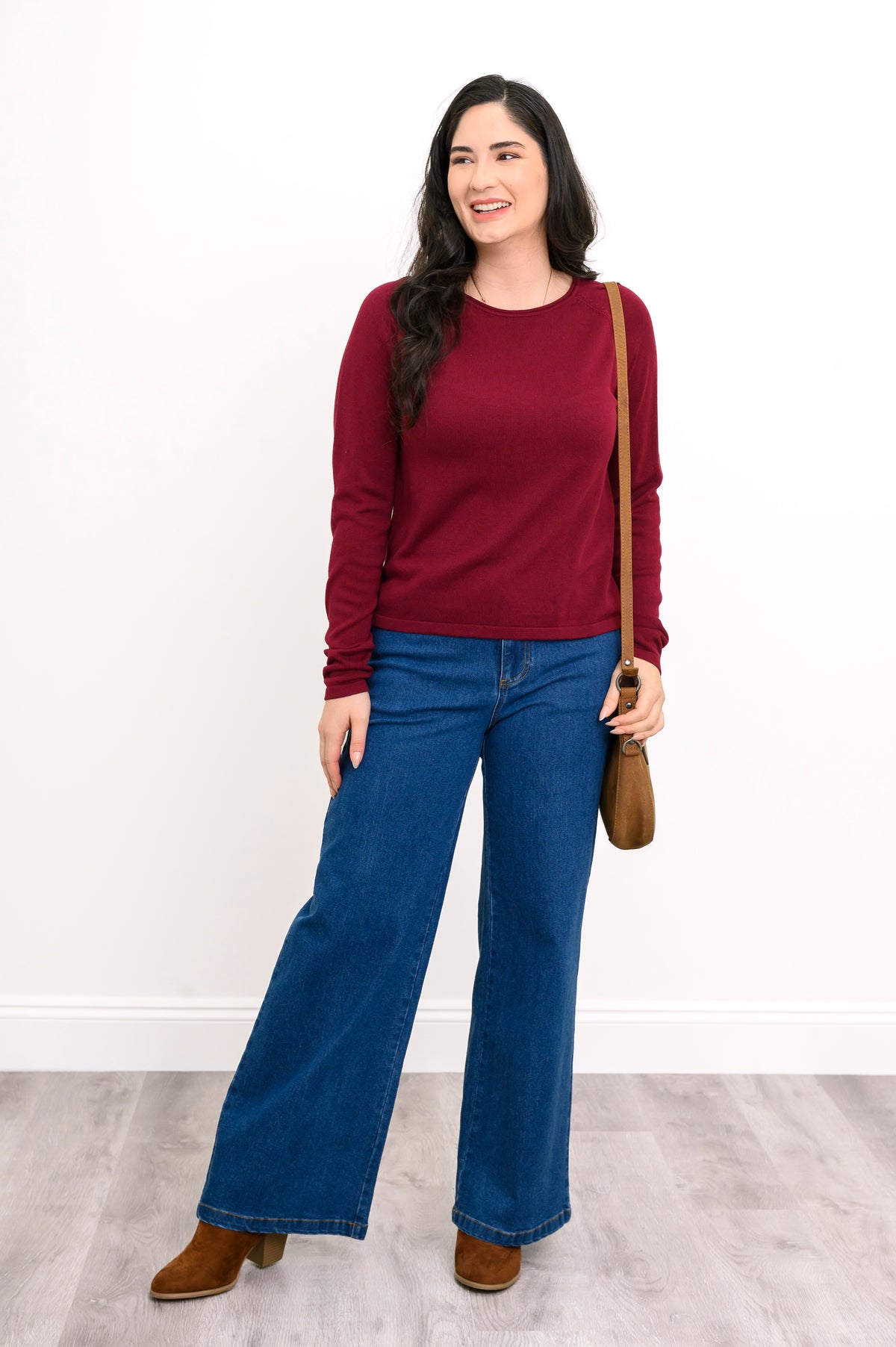 Front view of a vibrant dark red knit sweater and denim pants, highlighting a comfortable, body-skimming drape.