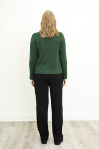 Back view of a women's long-sleeve deep moss knit top, styled with black pants against a plain white backdrop.