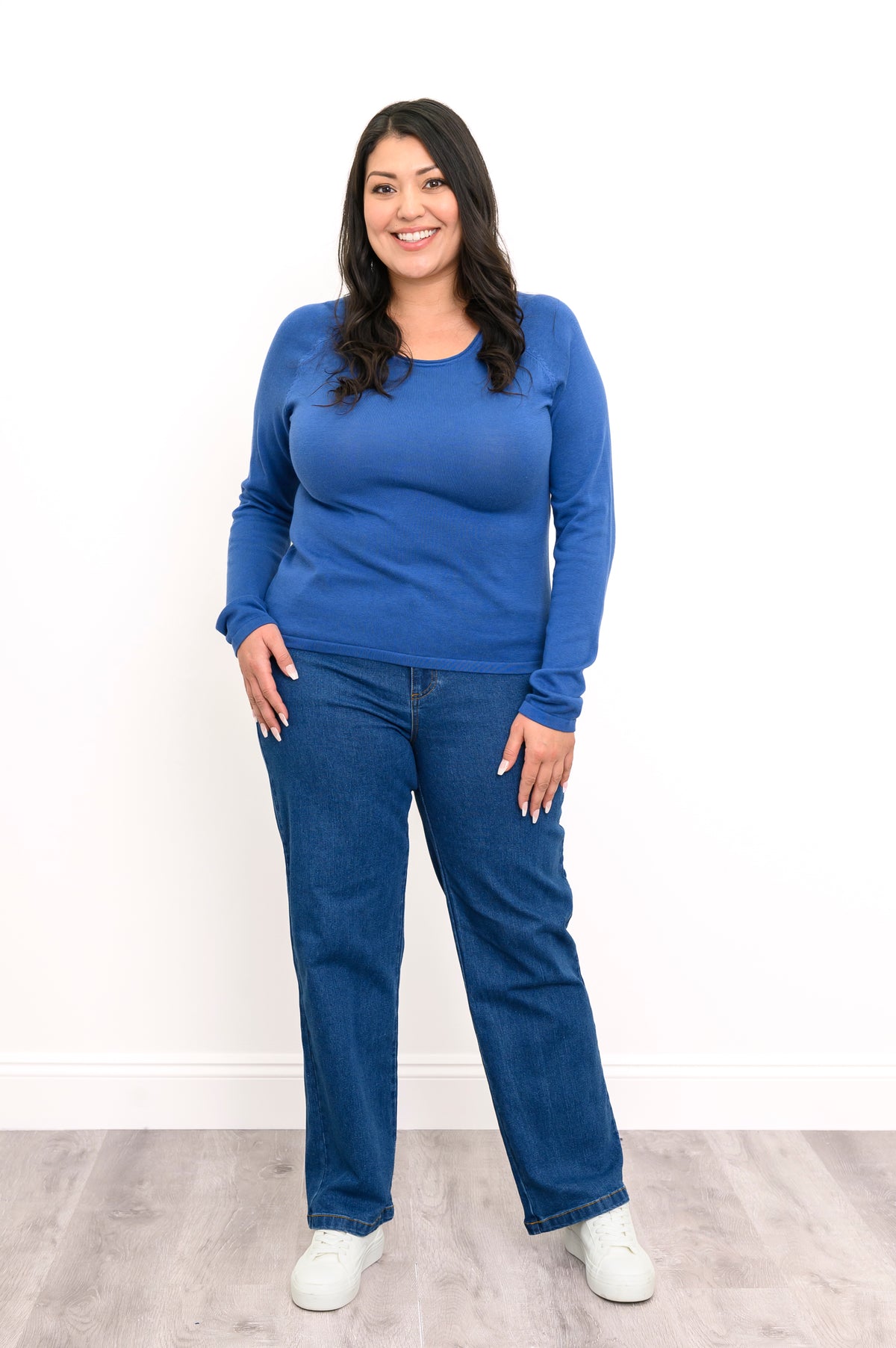 Front view of a loose-fit women's blue raglan sweater, showcasing a straight-cut hemline and relaxed silhouette.