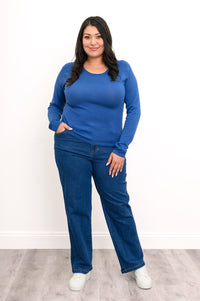 Smiling woman wearing a pacific blue knit sweater with a loose scoop neckline and comfortable long raglan sleeves.