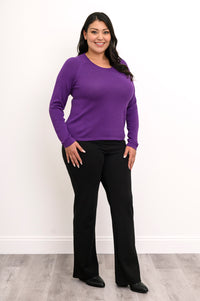 Aubergine scoop neck top with an extended sleeve length, styled casually with loose dark pants, full body shot.