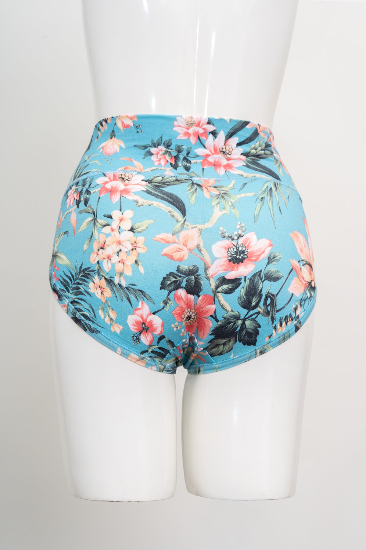 Teal tropical print high rise brief underwear shown on a white display mannequin against a plain backdrop.