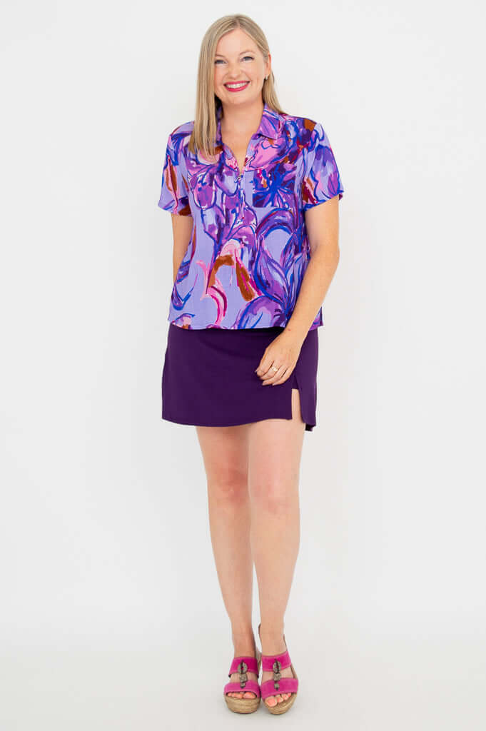 Front view of model in Lala top, purple skirt, and pink sandals