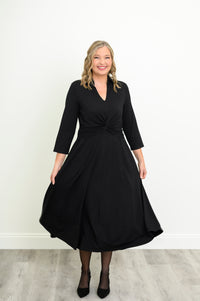 Woman in a black bamboo midi dress with a twist-front waist, V-neckline, and 3/4 sleeves