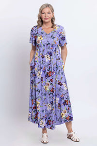 Woman wearing a lavender floral maxi dress with flutter sleeves, standing facing forward