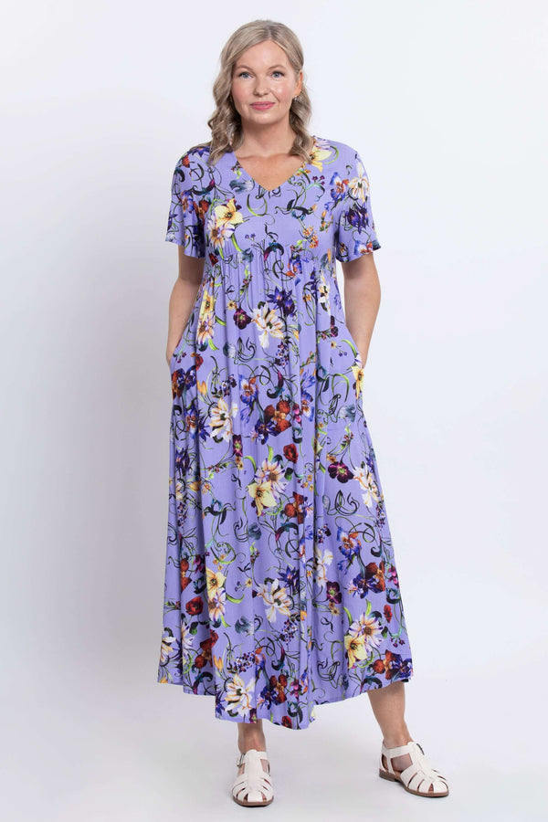 Woman wearing a lavender floral maxi dress with flutter sleeves, standing facing forward