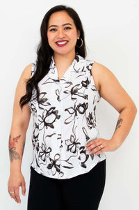 Woman wearing a sleeveless collared black and white floral print shirt, smiling