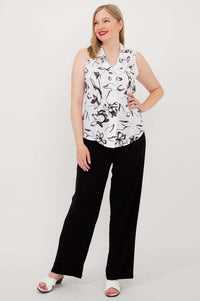 Woman in sleeveless black and white shirt and black wide-leg pants