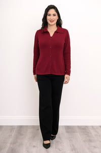 A professional woman wearing an open-front wine-colored knit top with long sleeves and front buttons.
