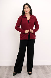 Hip-length deep red button-down sweater styled with casual black trousers for a clean, modern look.