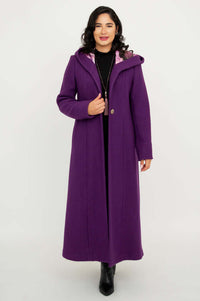 Woman wearing a long purple hooded coat, standing facing front with hands by her sides