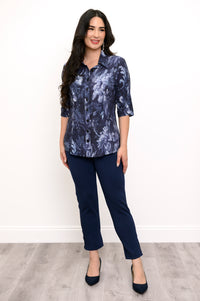 Full body front view of woman modeling dark blue floral print top and navy blue pants