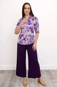 Woman modeling a purple floral blouse paired with wide-leg purple pants