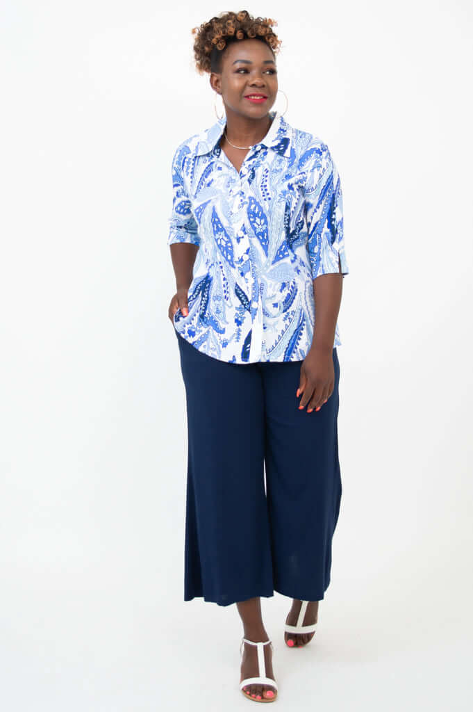 Woman in a blue and white paisley blouse and navy wide-leg pants, front diagonal view