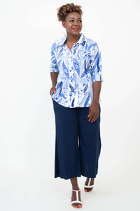 Woman in a blue and white paisley blouse and navy wide-leg pants, front diagonal view