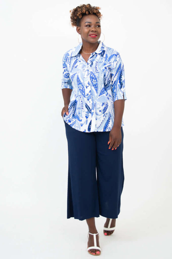 Woman in a blue and white paisley blouse and navy wide-leg pants, front diagonal view