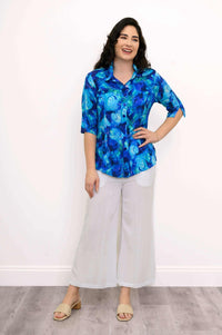 Model in Lorine blue blouse paired with white wide-leg pants and sandals