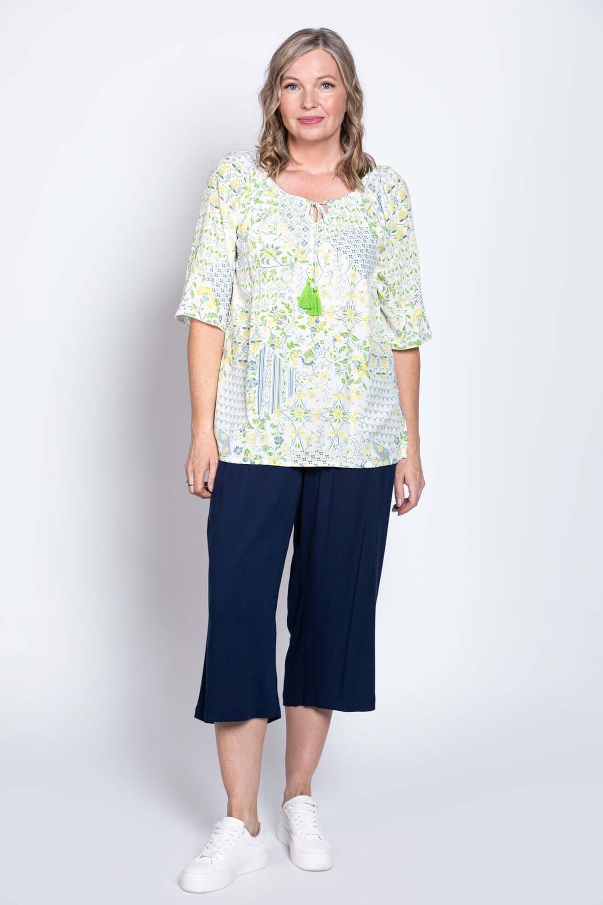 Full body view of woman in Luna Boho Peasant Top and navy relaxed pants