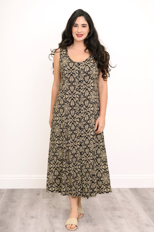 Full body shot of woman wearing black and beige patterned maxi dress against a white background