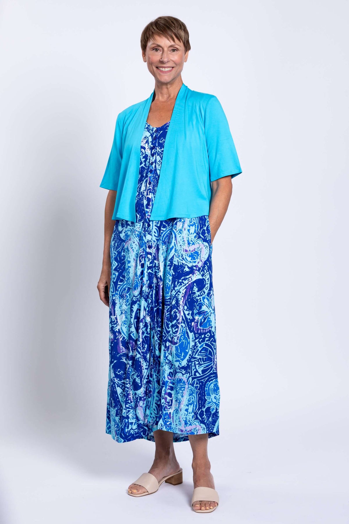 Woman in Madison blue printed maxi dress and turquoise cardigan smiling
