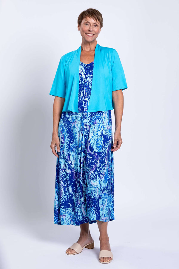 Woman wearing Madison blue printed maxi dress paired with a short turquoise cardigan