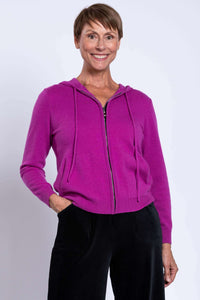 Woman wearing magenta zip-up wool cashmere hoodie with hood and front pockets
