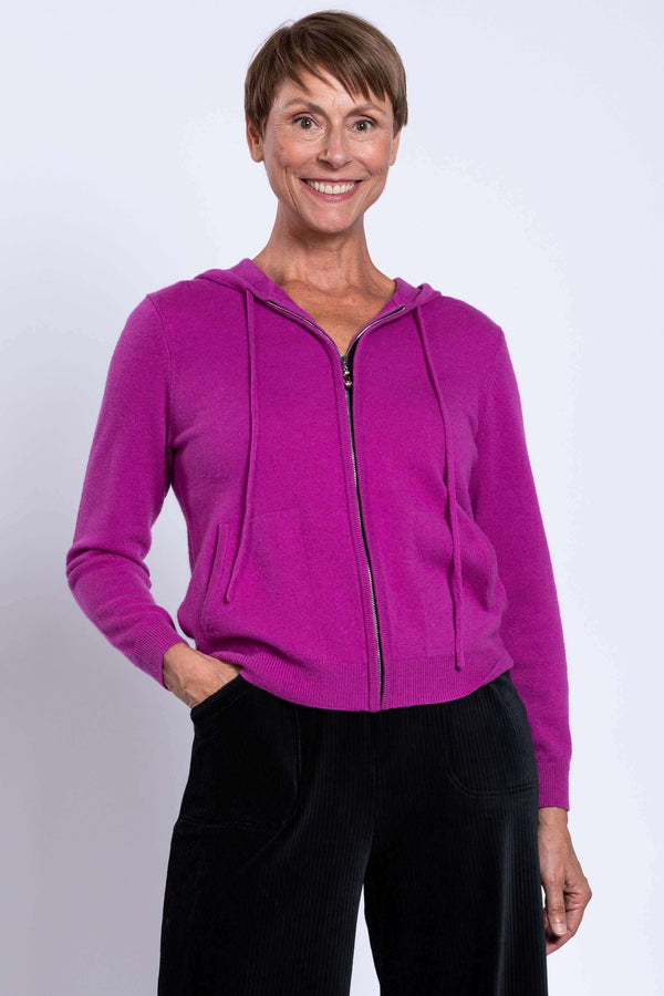 Woman wearing magenta zip-up wool cashmere hoodie with hood and front pockets