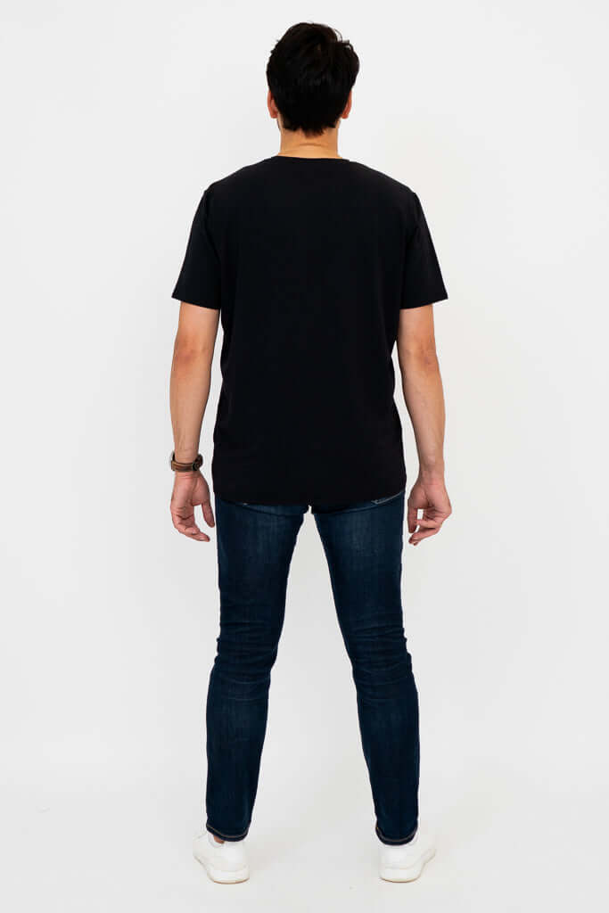 Man in black t-shirt and jeans, back view standing