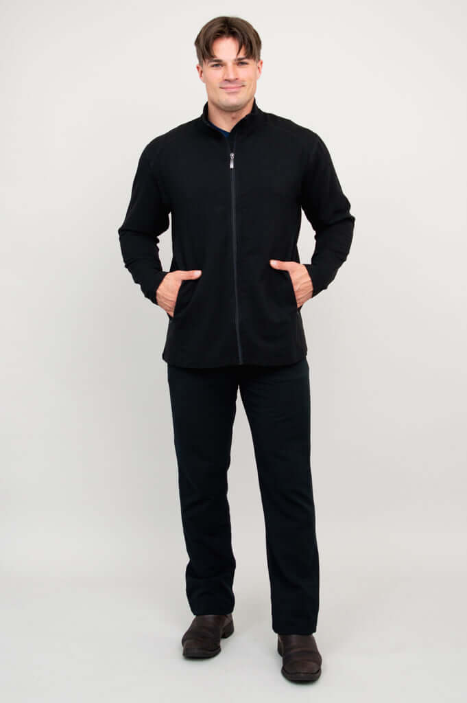 Man wearing black full-zip jacket, both hands in pockets