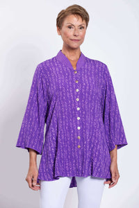 Front close-up of woman wearing a purple printed blouse with mandarin collar and button front