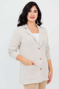 Front view of woman wearing the Margaret beige cotton cardigan with notched lapel and gold buttons