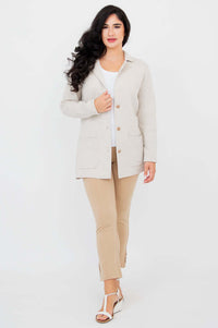 Woman walking forward wearing the Margaret cardigan, showing front pockets and button details
