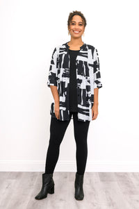 Full-length front view of a smiling woman wearing an open black and white geometric print tunic blouse 