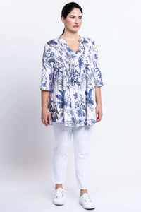 Three-quarter front view of model in floral Margate blouse and white pants