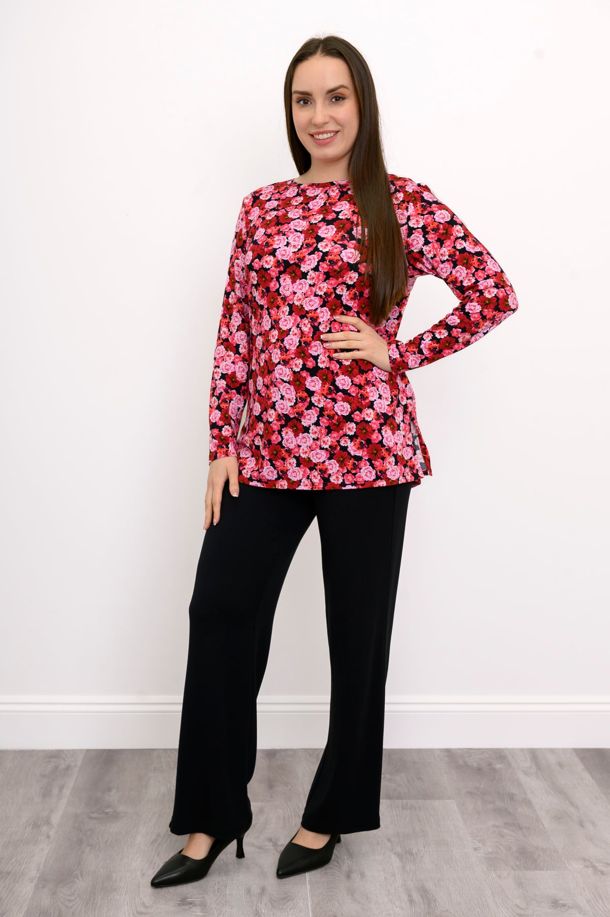 Model posing at an angle in a patterned pink three-quarter sleeve top, highlighting its loose, draped silhouette.