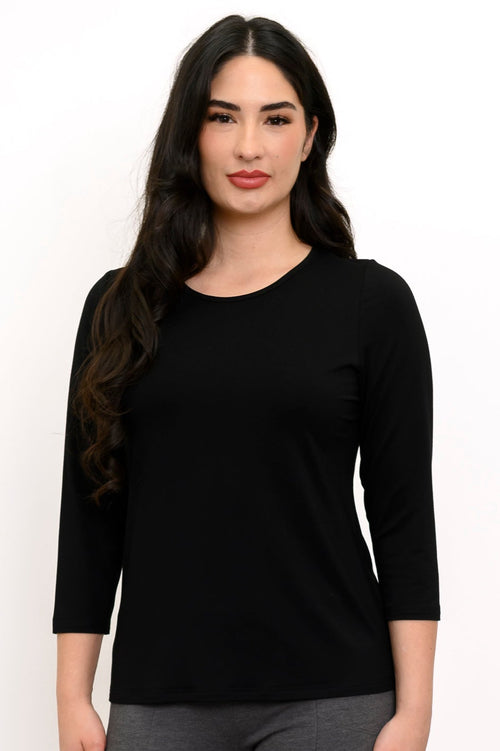 Woman wearing a black long-sleeve top against a white background, front view
